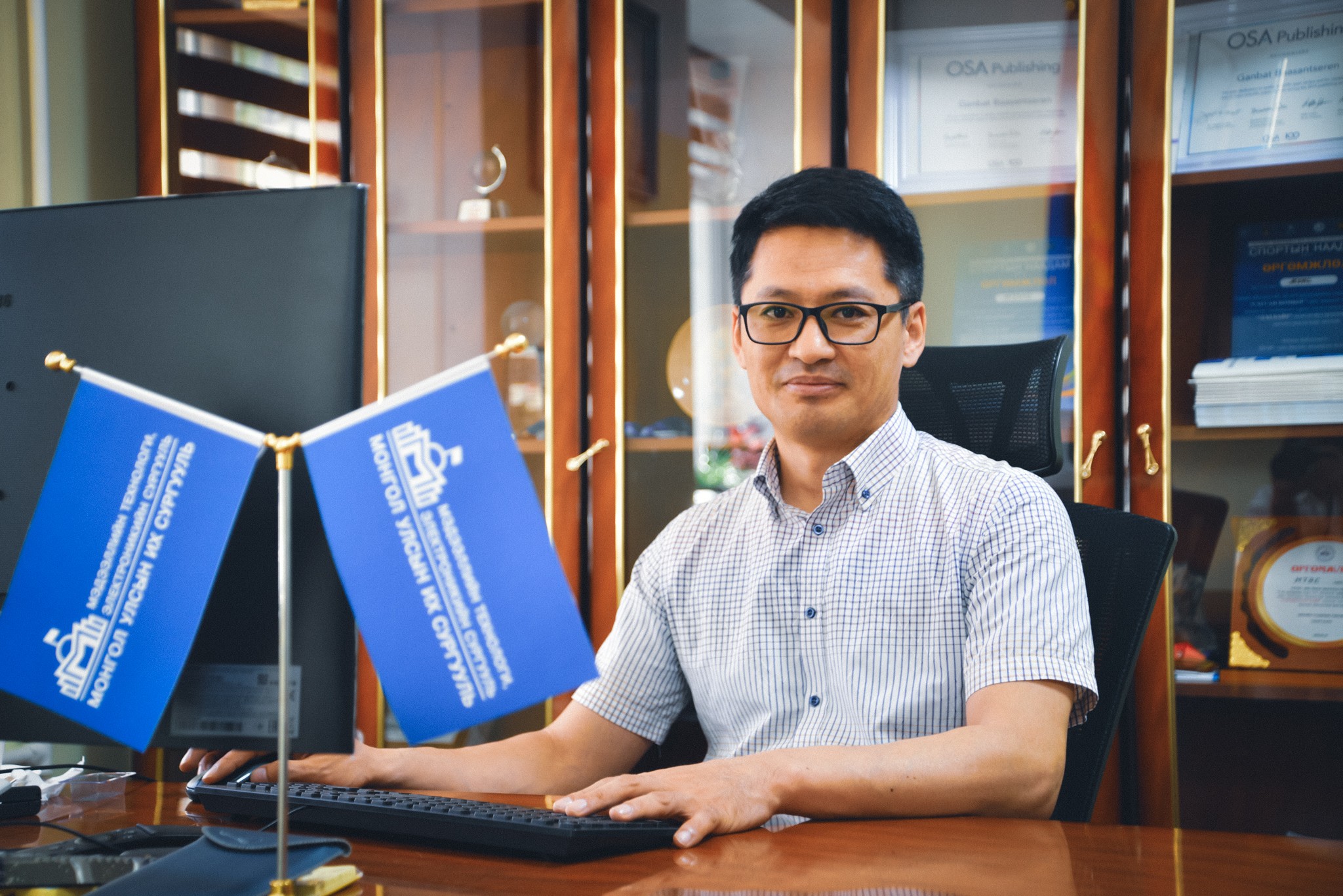 A person sitting at a desk with a computerDescription automatically generated